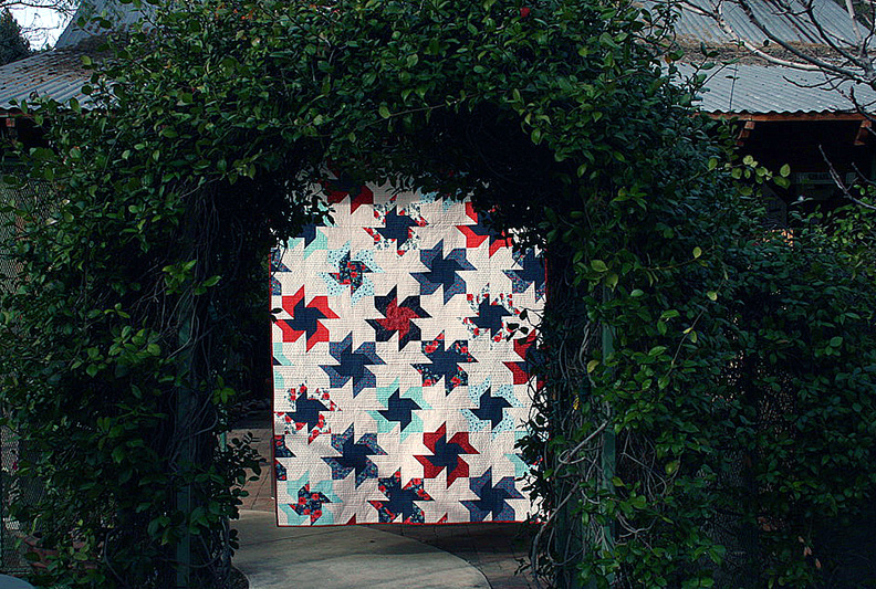 Scrappier Double Pinwheel quilt in a garden arch