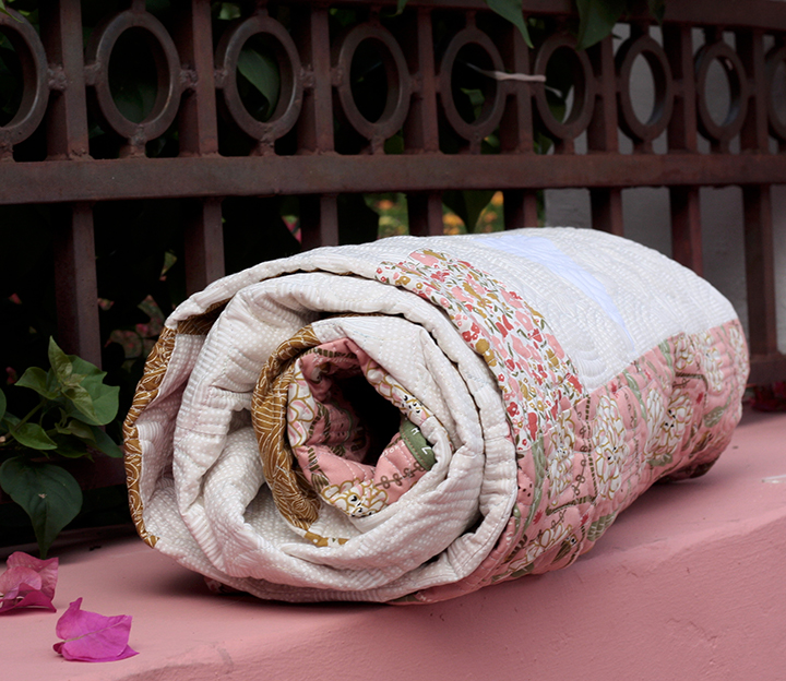 Quilt roll with the rod iron fence in the background